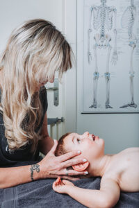 Sophie Antille effectuant une séance de crânio-thérapie douce sur un enfant pour favoriser son équilibre et sa détente.