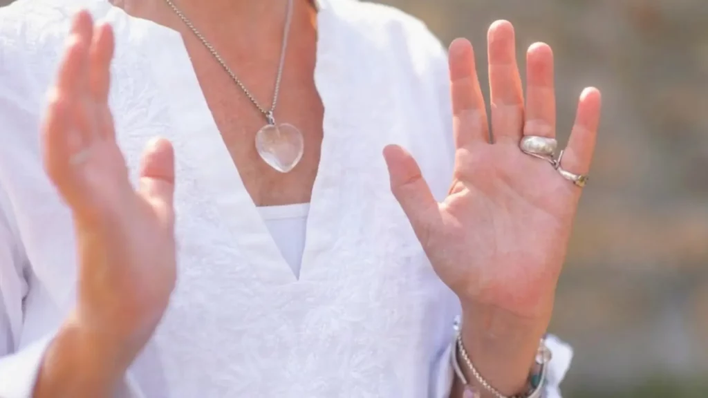 Femme pratiquant un soin énergétique avec les mains levées, illustrant la formation LaHoChi.